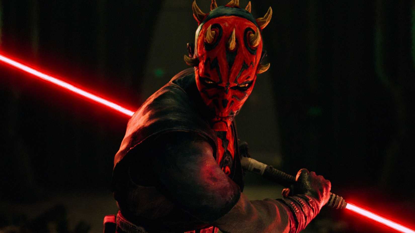 An image from Star Wars: Maul – Shadow Lord. It depicts Darth Maul, an alien with red skin, dark markings and a double-sided red lightsaber, glaring.