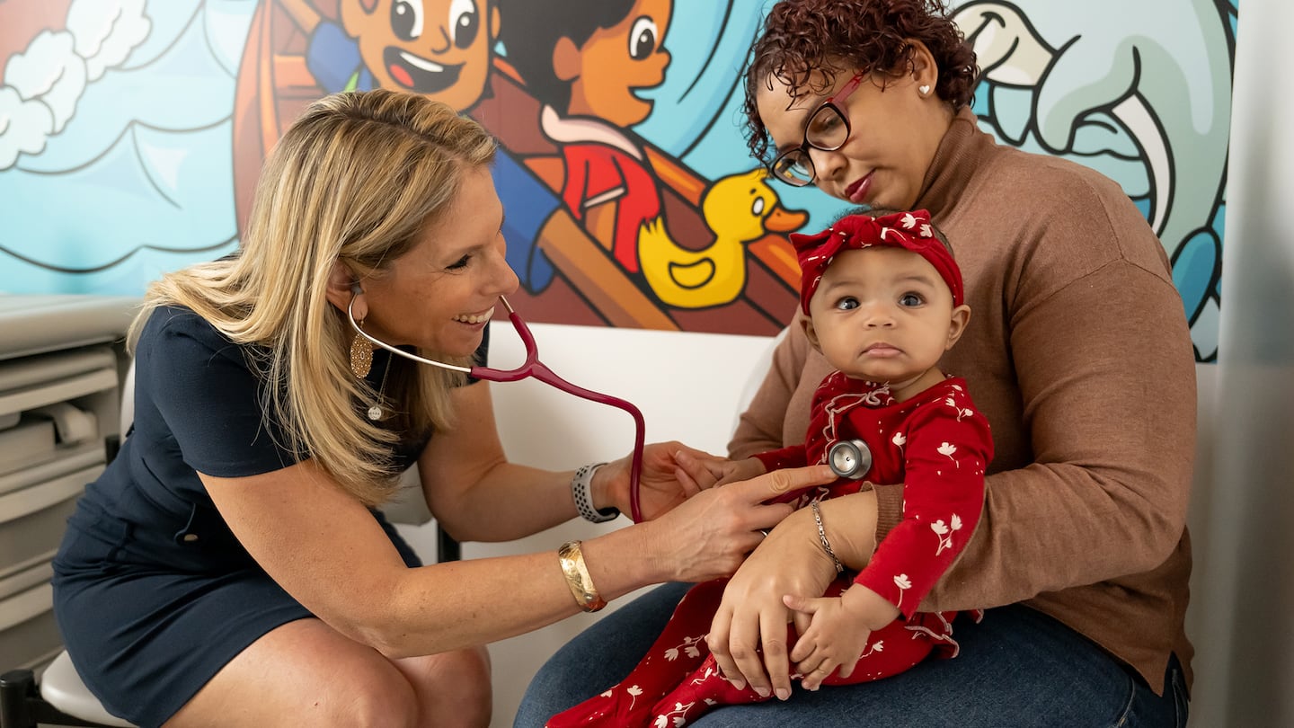 Dr. Robyn Riseberg with a patient and mother in Boston Community Pediatrics' South End offices.