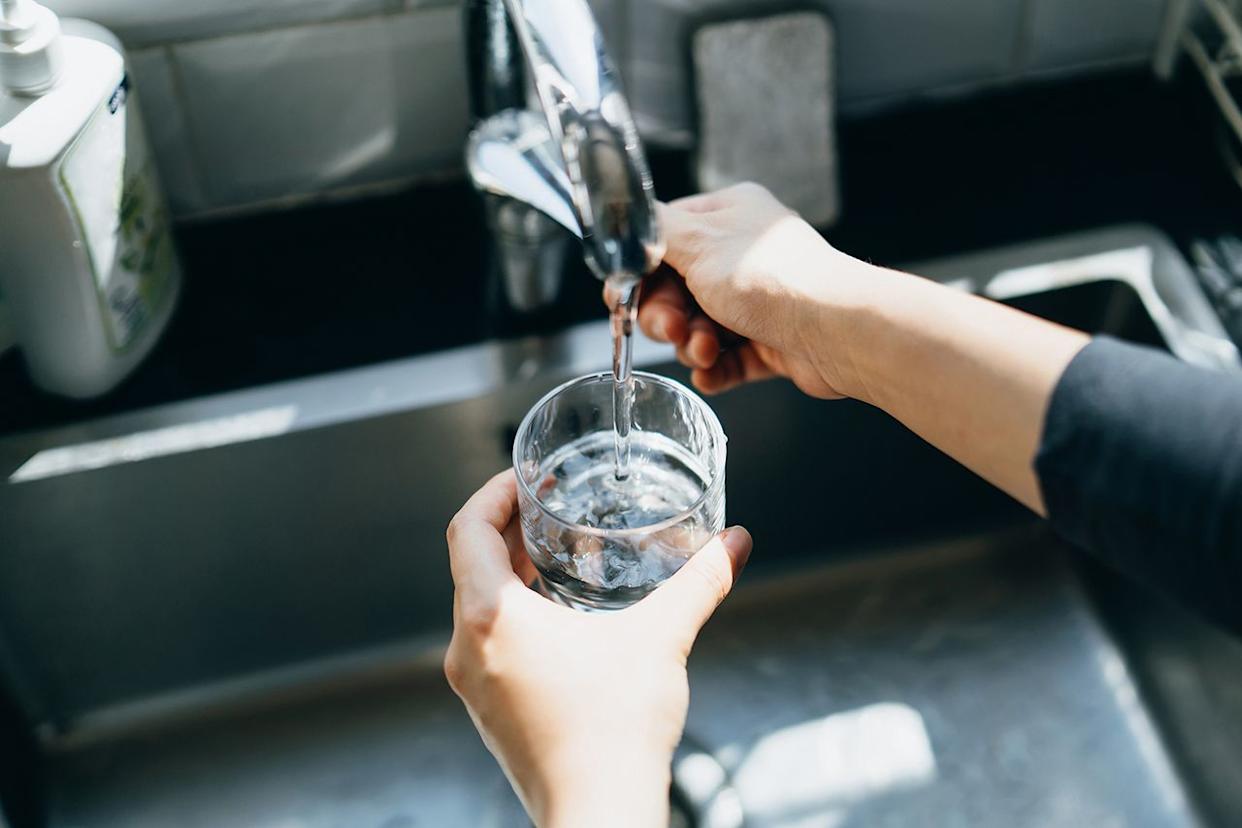 Stock image of someone pouring water from their tap. Getty