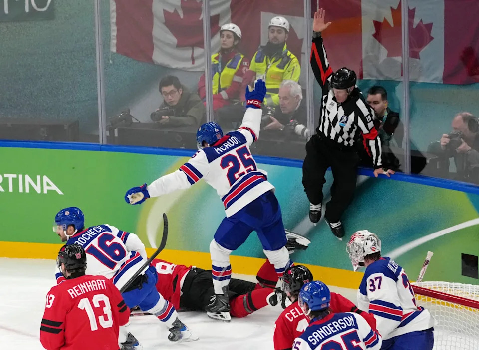 Feb 22, 2026; Milan, Italy; Charlie McAvoy of the United States stumbles over Cale Makar of Canada as judge Olga Polyuk of Ukraine calls a penalty during the men's ice hockey gold medal game during the Milano Cortina 2026 Olympic Winter Games at Milano Santagiulia Ice Hockey Arena. Mandatory Credit: James Lang-Imagn Images© James Lang-Imagn Images