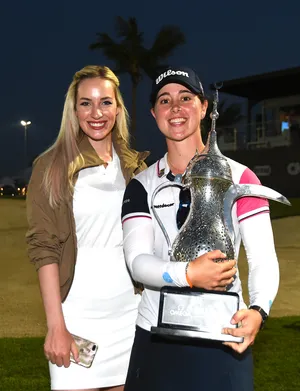 Winner Nuria Iturrios of Spain and Paige Spiranac of United States pose with the trophy during the Omega Dubai Moonlight Classic.