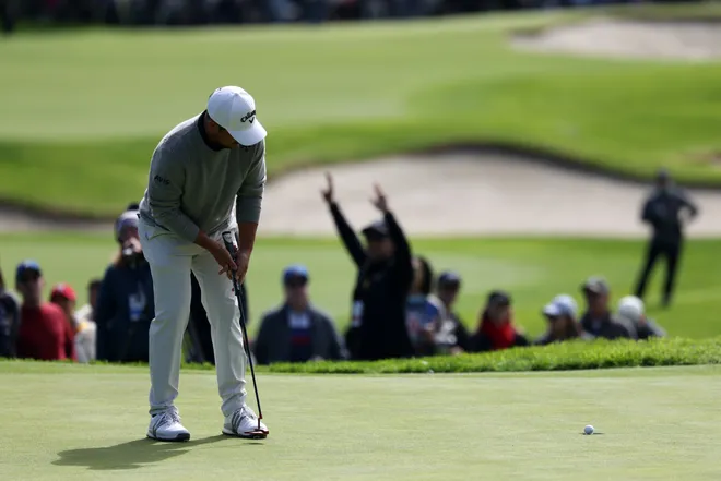 Xander Schauffele holes a putt on the ninth green during the second round of The Genesis Invitational
