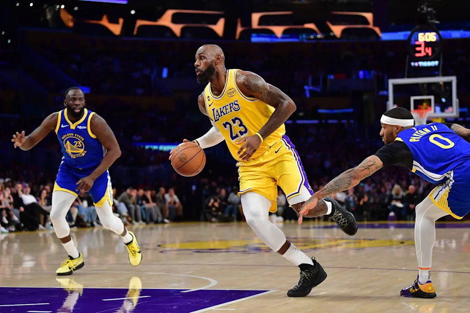 Feb 7, 2026; Los Angeles, California, USA; Los Angeles Lakers forward LeBron James (23) moves to the basket against Golden State Warriors guard Gary Payton II (0) and forward Draymond Green (23) during the first half at Crypto.com Arena. Mandatory Credit: Gary A. Vasquez-Imagn Images