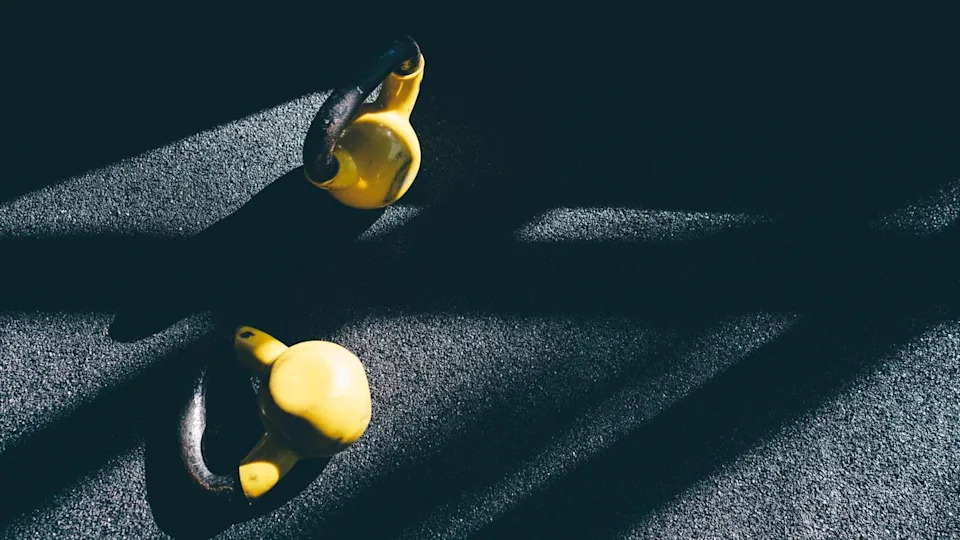 Two kettlebells lying on floor for farmer's carry exercise.