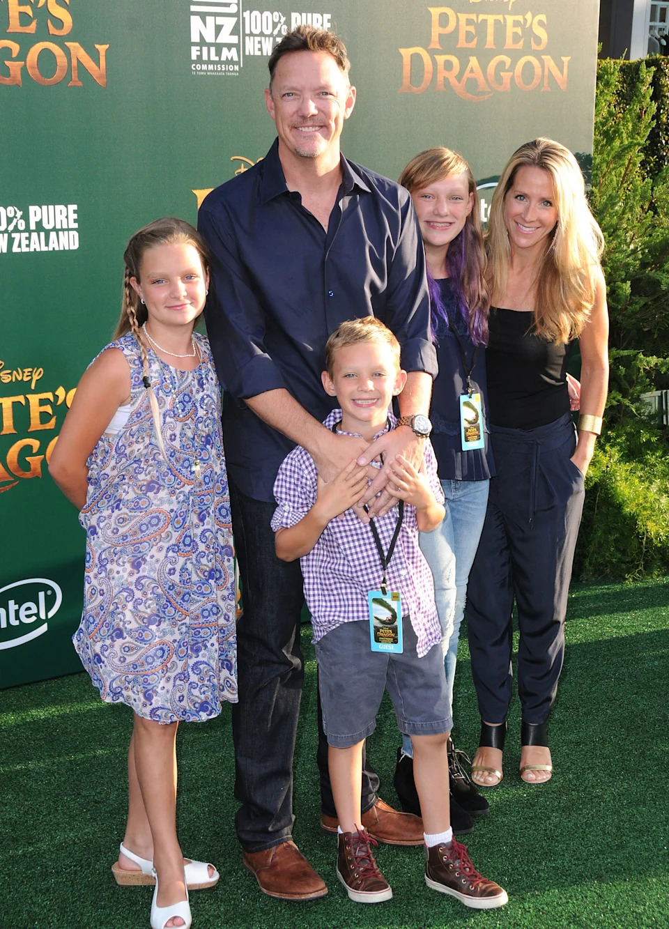 Actor Matthew Lillard with his wife, Heather Helm, and their three children at a 2016 movie premiere. Family of five posing on a red carpet in front of a green backdrop that reads: Pete’s Dragon.