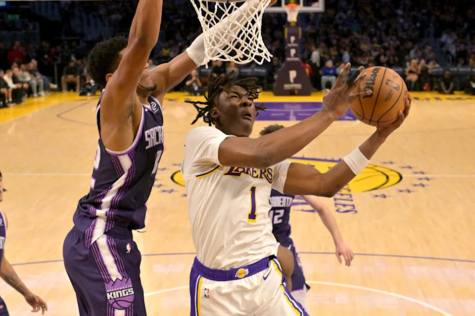 Dec 28, 2025; Los Angeles, California, USA; Sacramento Kings center Dylan Cardwell (32) defends Los Angeles Lakers forward Adou Thiero (1) in the second half at Crypto.com Arena. Mandatory Credit: Jayne Kamin-Oncea-Imagn Images