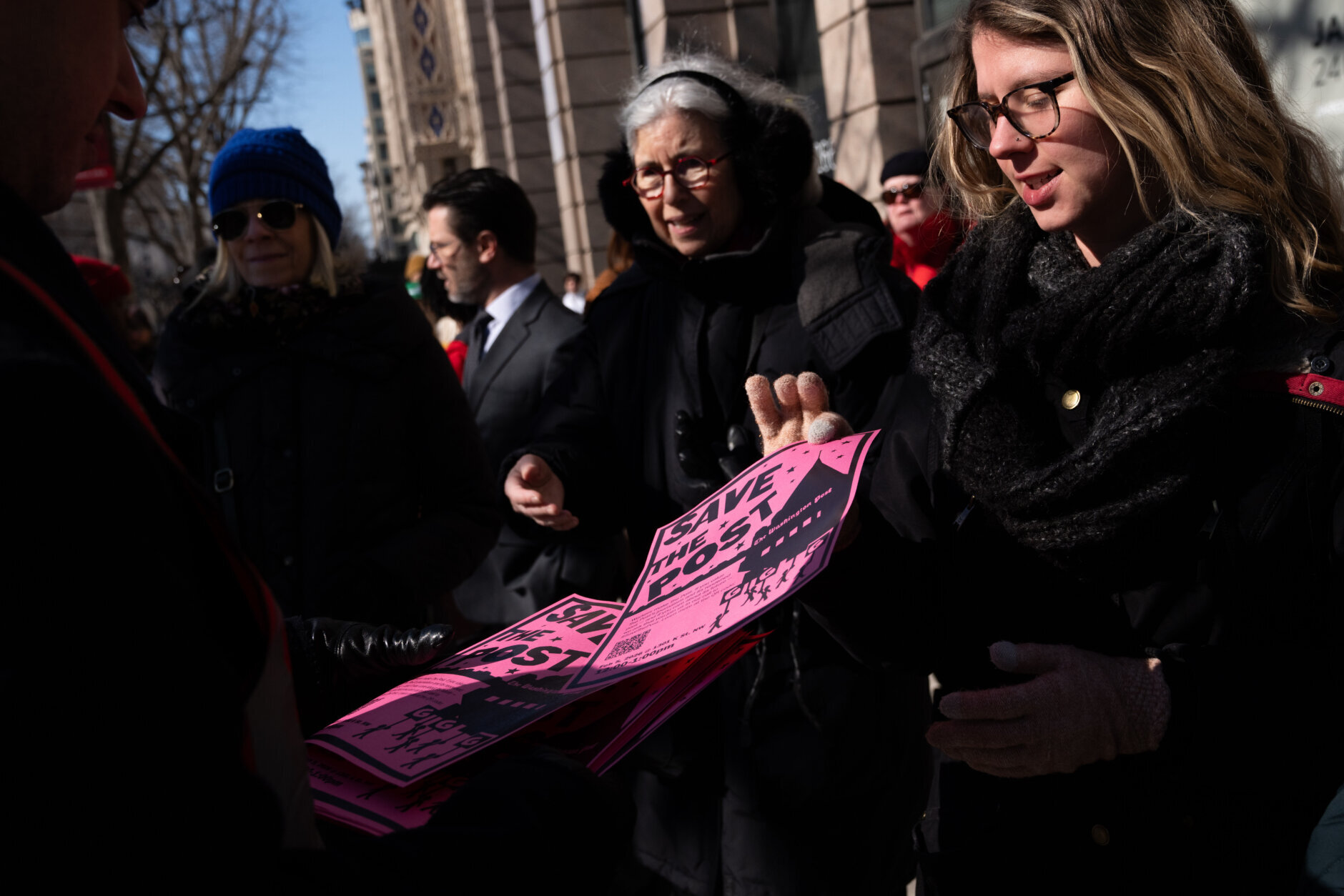 Protesters outside of the Washington Post office take flyers following a mass layoff, Thursday, Feb. 5, 2026, in Washington. (AP Photo/Allison Robbert)
