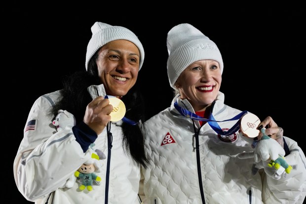 United States' gold medalist Elana Meyers Taylor, left, and United States' bronze medalist Kaillie Armbruster Humphries, right, pose with their medals after the women's monobob competition at the 2026 Winter Olympics, in Cortina d'Ampezzo, Italy, Monday, Feb. 16, 2026. (AP Photo/Alessandra Tarantino)