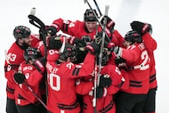 Team Canada players celebrate their overtime win against Czechia in a men's ice hockey...