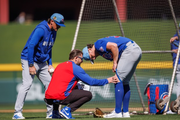Cubs trainers check on pitcher Ryan Rolison after he was hit by a ball from Seiya Suzuki during live batting practice at spring training on Feb. 19, 2026, at Sloan Park in Mesa, Ariz. (Armando L. Sanchez/Chicago Tribune)