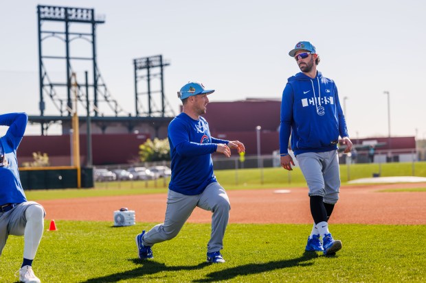 Cubs third baseman Alex Bregman, left, talks with shortstop Dansby Swanson while warming up during spring training at Sloan Park on Feb. 19, 2026, in Mesa, Ariz. (Armando L. Sanchez/Chicago Tribune)