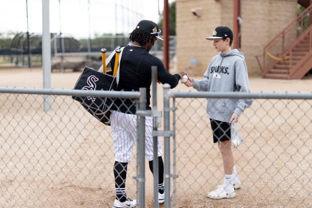 White Sox second baseman Luisangel Acuña signs a baseball for James Dykes, 14, of Elmurst, during spring training at Camelback Ranch on Feb. 18, 2026, in Glendale, Ariz. (Eileen T. Meslar/Chicago Tribune)