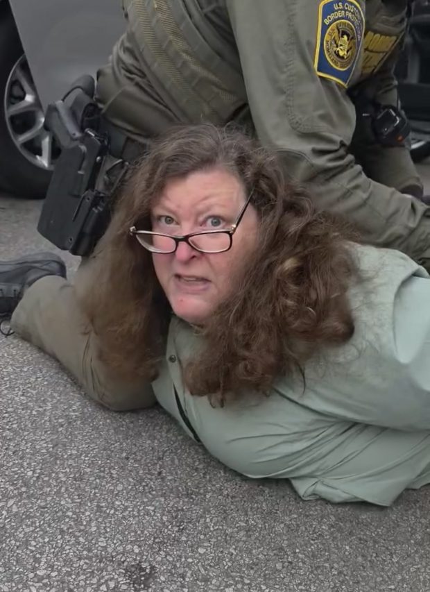 In an image taken from video, federal immigration agents detain two people on the 2400 block of West Foster Avenue, including a Spanish speaking man and Debbie Brockman, who worked as a producer for WGN. (Josh Thomas)