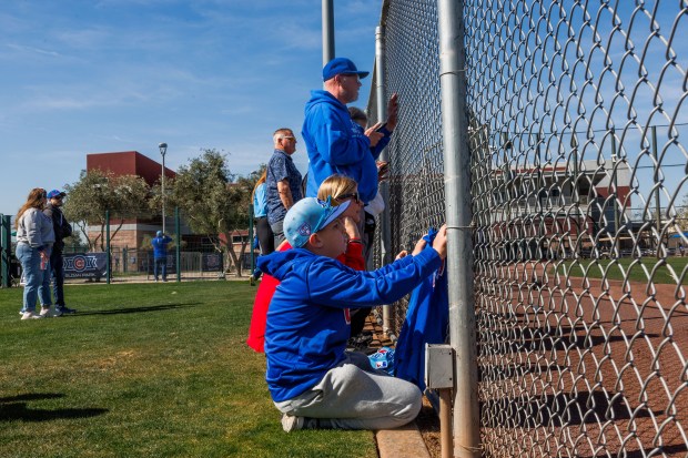 Sarah Mackey and her 11-year-old son, Braxton Mackey, of Kansas, watch Cubs players practice during spring training at Sloan Park on Feb. 19, 2026, in Mesa, Ariz. (Armando L. Sanchez/Chicago Tribune)