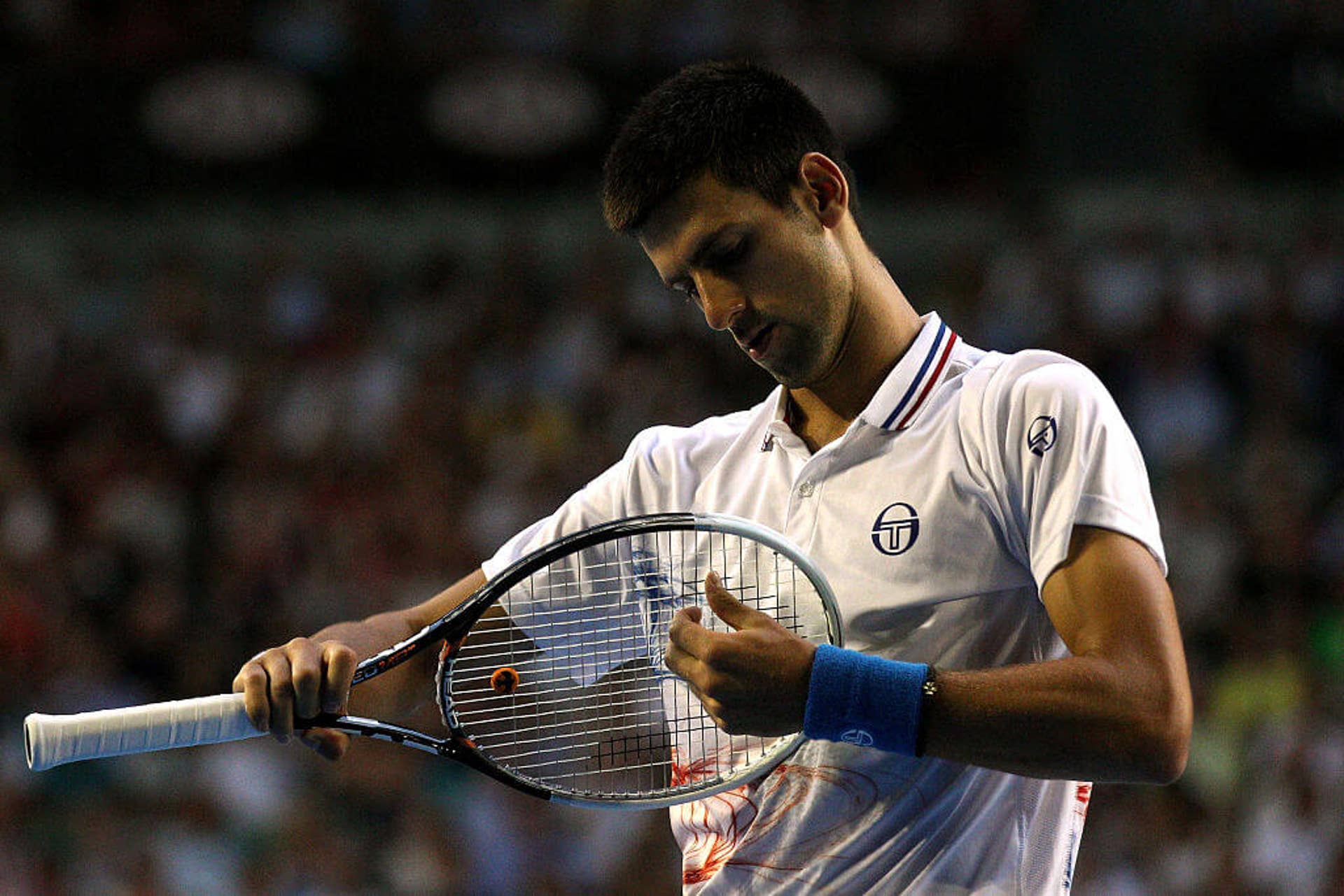 Novak Djokovic adjusts his racket during the final match of the 2012 Australian Open.