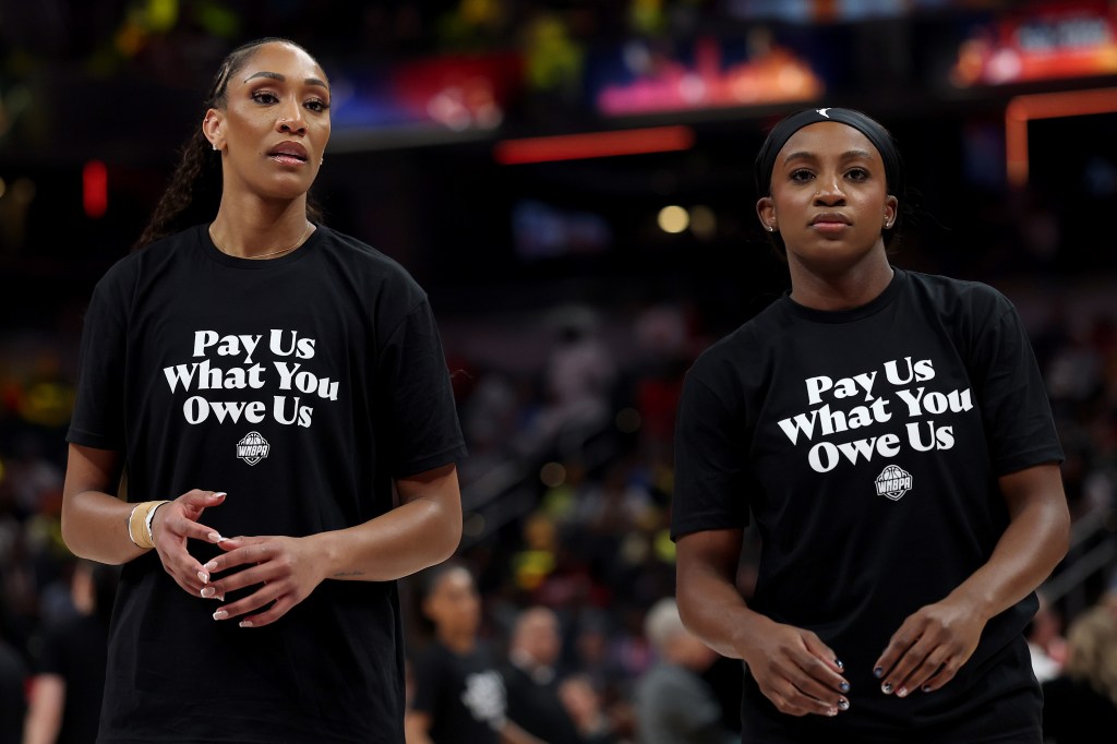 A’ja Wilson #22 of the Las Vegas Aces and Jackie Young #0 of the Las Vegas Aces wear shirts saying "Pay us what you owe us" prior to the 2025 AT&T WNBA All-Star Game 
