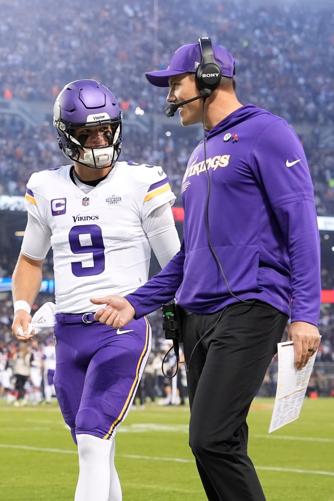 Head coach Kevin O'Connell and J.J. McCarthy of the Minnesota Vikings speak on the field.