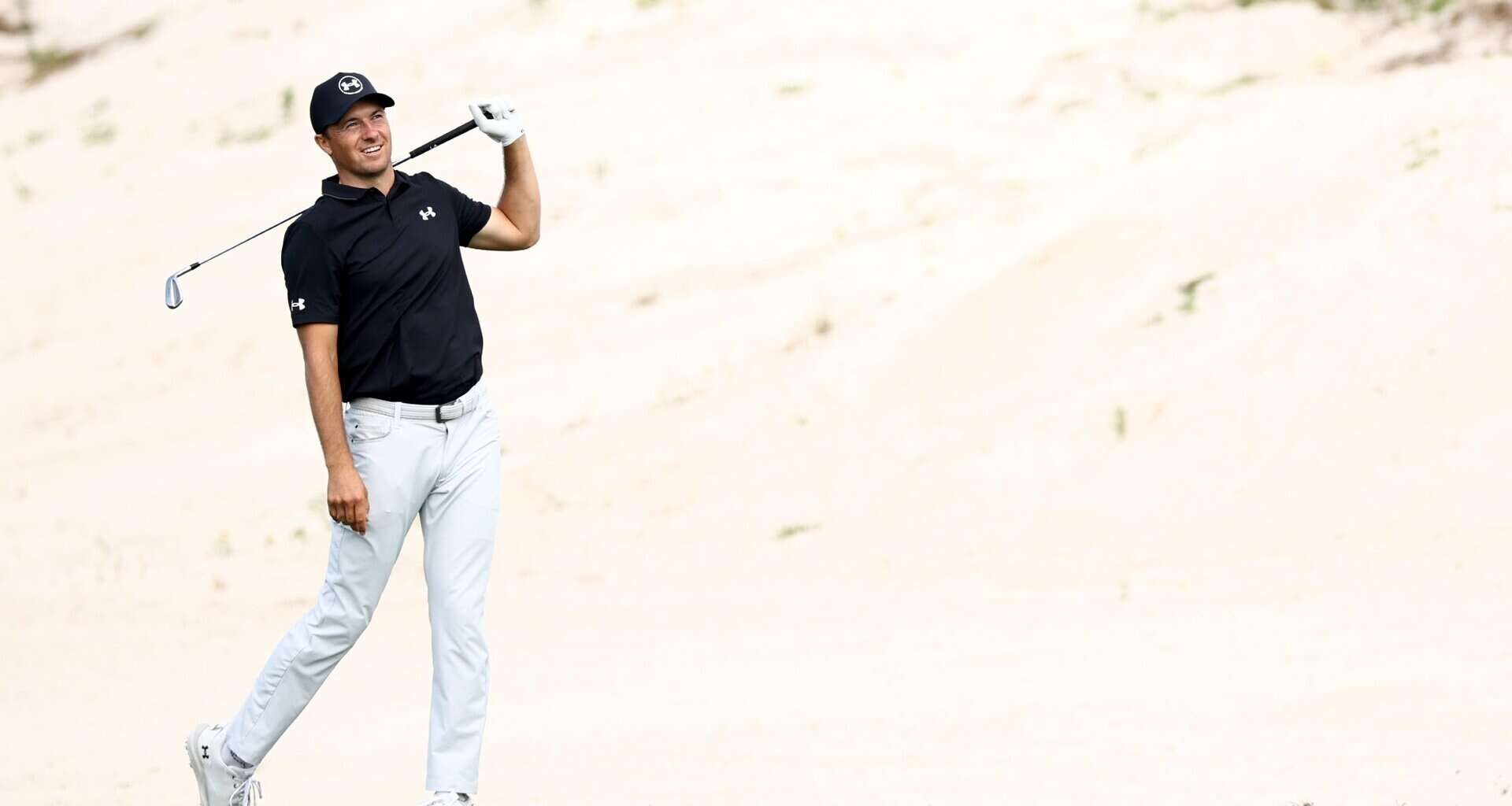 Jordan Spieth walking on a golf course with a club, at the 2025 Hero World Challenge