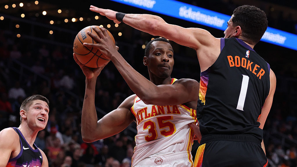 ATLANTA, GEORGIA - JANUARY 23: Christian Koloko #35 of the Atlanta Hawks drives against Devin Booke...