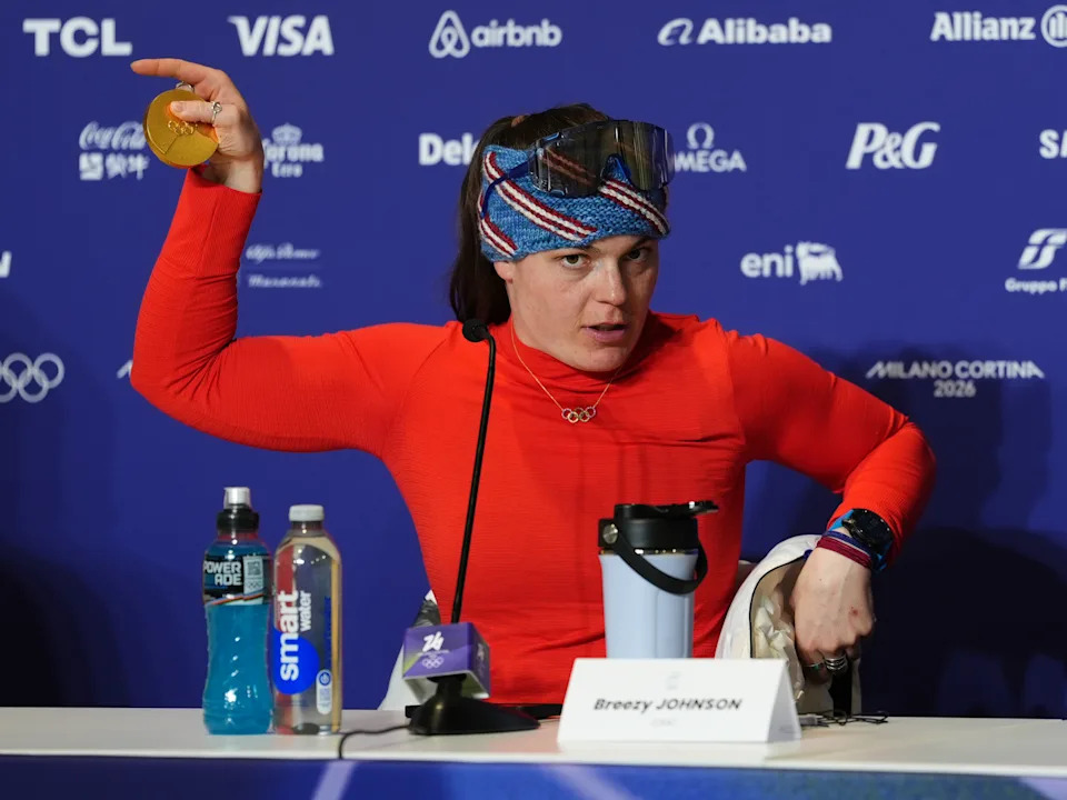 Breezy Johnson shows her broken medal to the media following the race.