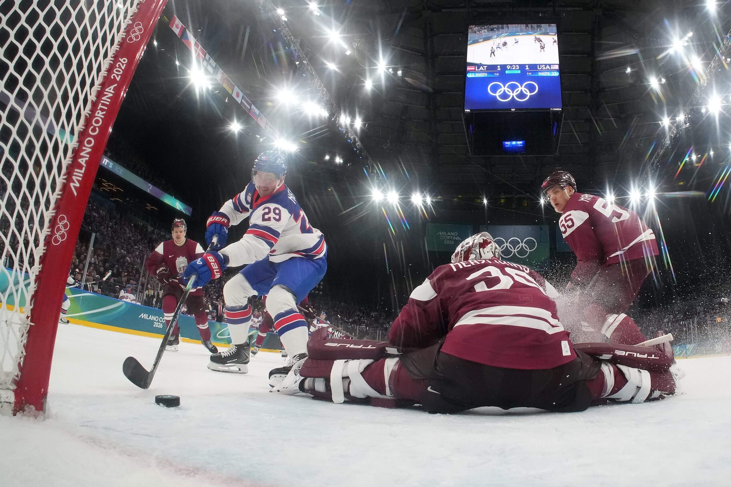 Brock Nelson #29 of Team United States scores a goal against Elvis Merzlikins #30 of Team Latvia. 