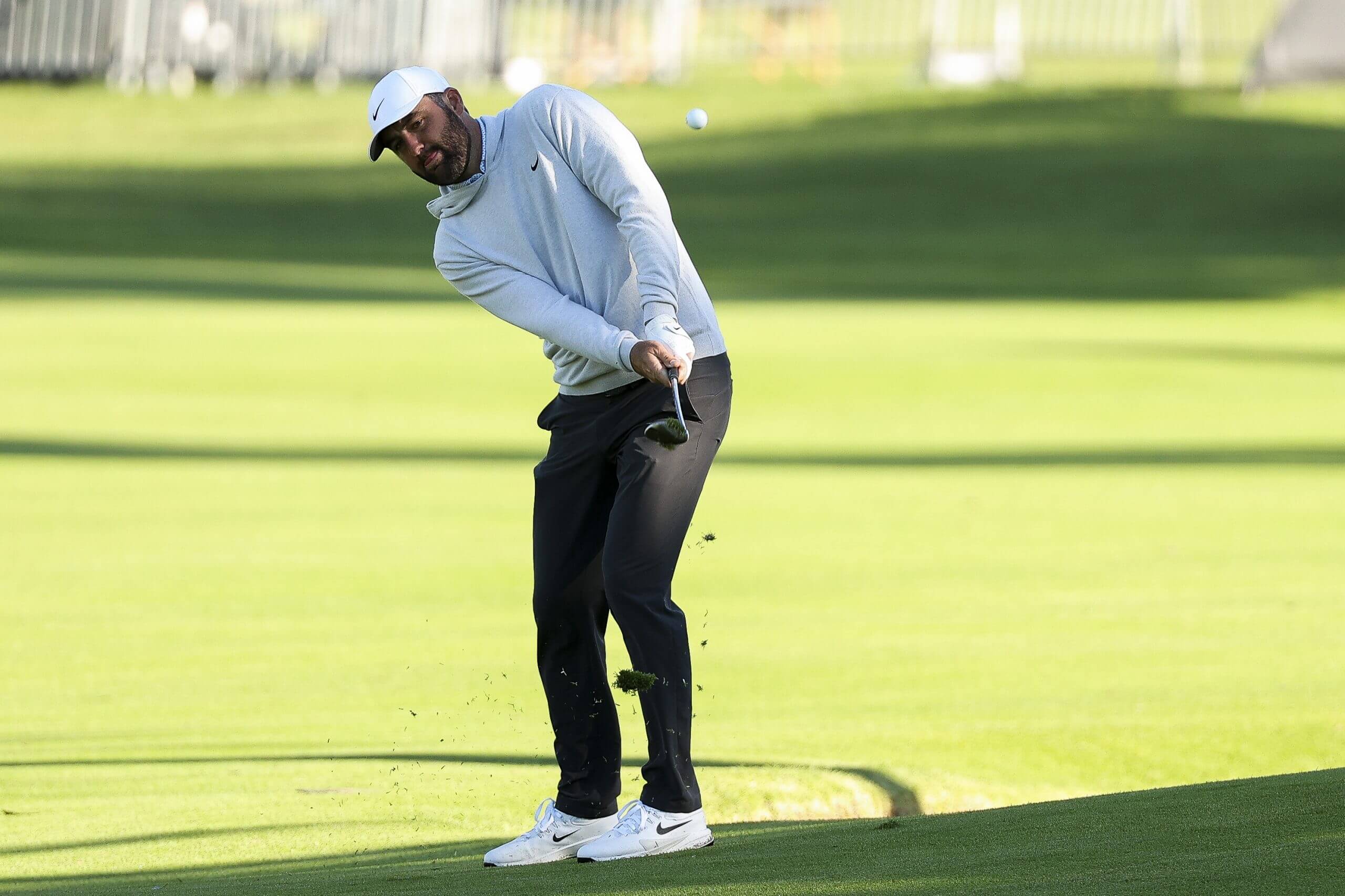 Scottie Scheffler strikes the ball on the fairway.