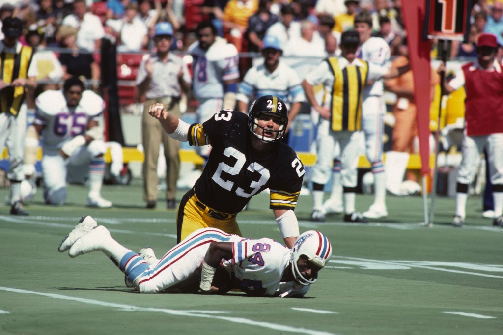 Defensive back Mike Wagner #23 of the Pittsburgh Steelers looks up after tackling wide receiver Billy Johnson #84 of the Houston Oilers during a game at Three Rivers Stadium circa 1979 in Pittsburgh, Pennsylvania.