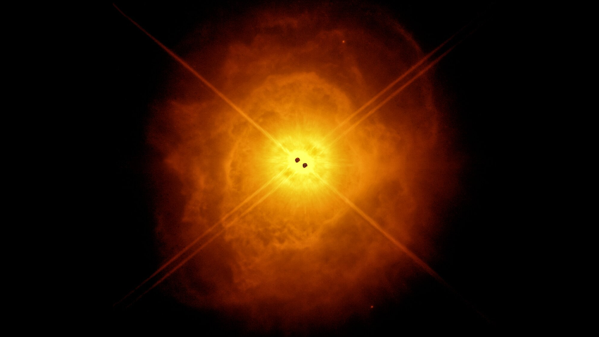 two black hots in the center surrounded by a dusty orange glowing egg-shaped cloud of gas and dust.