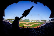 Fans cheer during the fifth inning of a spring training game between the Texas Rangers and...