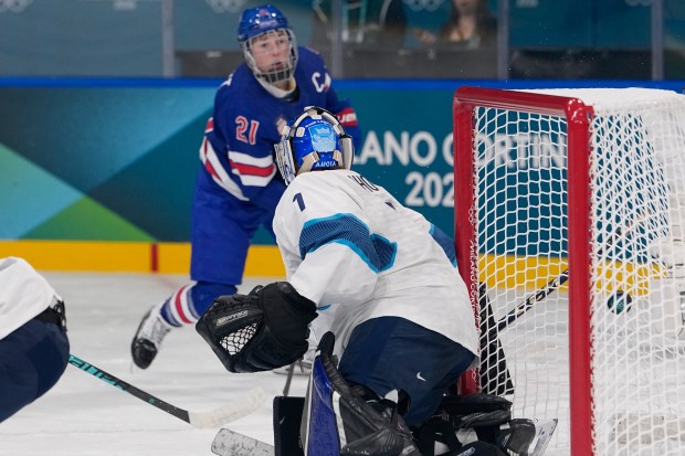 United States' Hilary Knight, back, shoots to score past Finland's Sanni Ahola during a preliminary round match of women's ice hockey between the United States and Finland at the 2026 Winter Olympics, in Milan, Italy, Saturday, Feb. 7, 2026. (AP Photo/Petr David Josek)