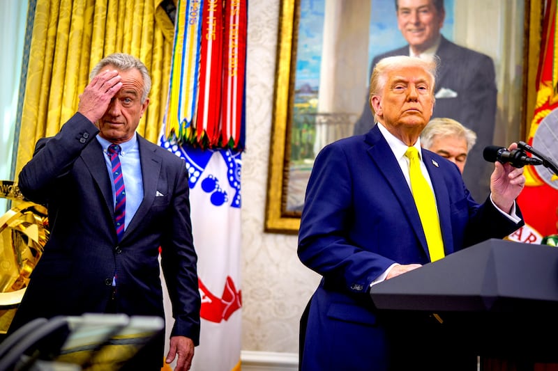 U.S. President Donald Trump, accompanied by Health and Human Services Secretary Robert F. Kennedy Jr. (L), takes a question