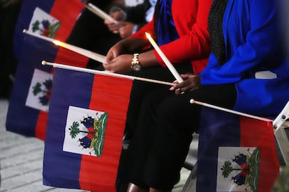 La gente sostiene banderas haitianas y velas durante una vigilia el martes 3 de febrero de 2026, en Miami.