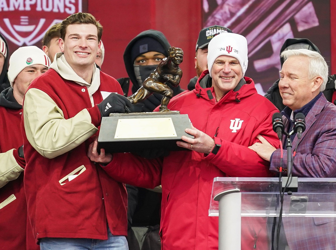 Jan 24, 2026; Bloomington, IN, USA; Indiana Hoosiers quarterback Fernando Mendoza (15) holds the Heisman Trophy with Indiana Hoosiers head coach Curt Cignetti on Saturday, Jan. 24, 2026, during the Indiana Football College Football Playoff National Championship celebration and parade at Memorial Stadium. Mandatory Credit: Grace Hollars-USA TODAY Network via Imagn Images