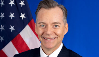 Closeup of Roger Nyhus and an American flag.