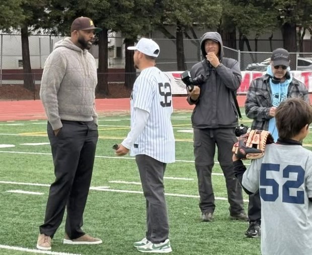 Vallejo High Athletic Director and head baseball coach Josh Ramos (middle with hat wearing No. 52) talks to CC Sabathia (far left) during Sabathia's ceremony at Corbus Field in November. Ramos had bought the jersey at Sabathia's MLB Hall of Fame induction ceremony during August and had it signed on this day. (Thomas Gase - Times-Herald)
