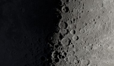 A NASA graphic showing a part of the moon's surface around its first quarter phase when its right half is lit by the sun and its left is in shadow. Large craters can be seen lining the night-day divide.