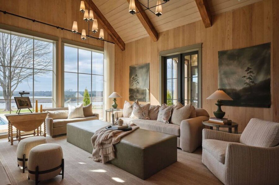 Claire Thompson's Interior Designs Are Soft, Warm, and Endlessly Livable - 4 A living room with a large couch and ottoman, featuring warm interiors from Claire Thompson Design.