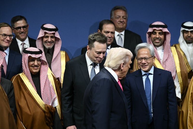 US President Donald Trump, Elon Musk (C), Nvidia founder and CEO Jensen Huang (R) and other attendees, arrive for a family picture the US-Saudi Investment Forum at the John F. Kennedy Center for the Performing Arts in Washington, DC on November 19, 2025.