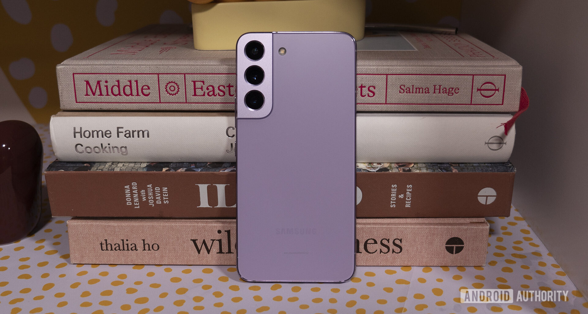 Samsung Galaxy S22 Bora Purple Leaning Against Books