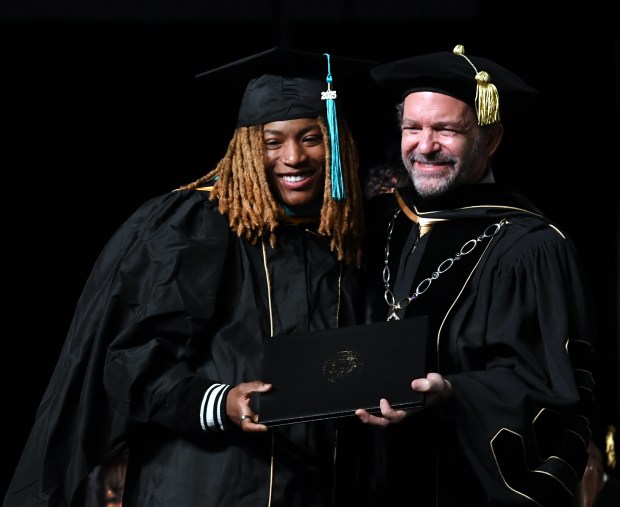University of Colorado president Todd Saliman, right, congratulates Jaylyn Sherrod as she receives a master's degree in criminal justice from the University of Colorado Denver during commencement ceremonies at the Colorado Convention Center on Dec. 13, 2025, in Denver. (Photo By Kathryn Scott/Special to The Denver Post)