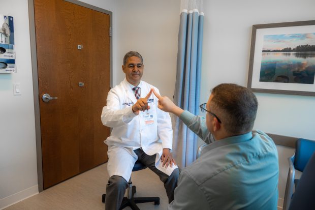 Dr. Bernardo Rodrigues with a patient. Rodrigues has been at UConn Health since 2015, and he founded the Parkinson's Disease Clinic at UConn. (Tina Encarnacion/UConn Health Photo)