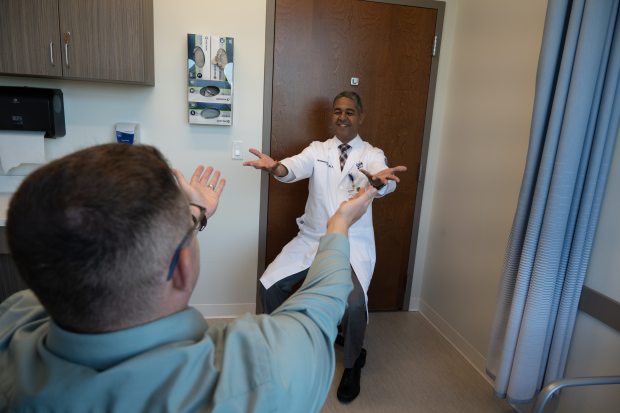 Dr. Bernardo Rodrigues with a patient. Rodrigues has been at UConn Health since 2015, and he founded the Parkinson's Disease Clinic at UConn. (Tina Encarnacion/UConn Health Photo)
