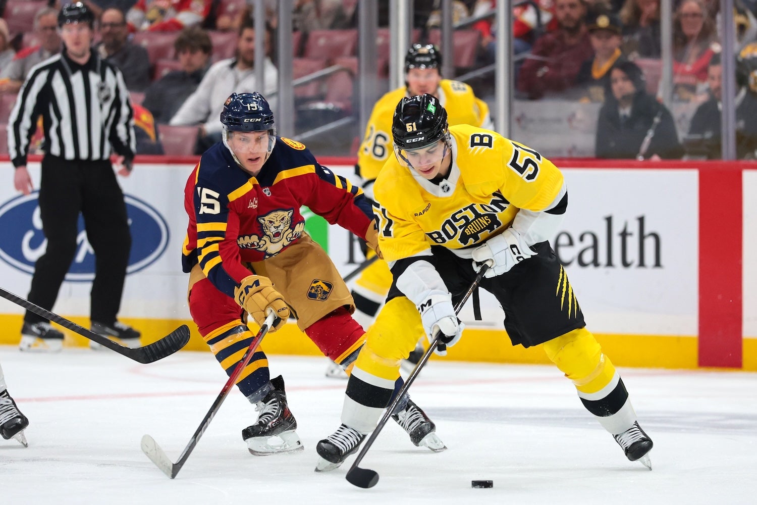 Feb 4, 2026; Sunrise, Florida, USA; ]Boston Bruins center Matthew Poitras (51) moves the puck against Florida Panthers center Anton Lundell (15) during the first period at Amerant Bank Arena. Mandatory Credit: Sam Navarro-Imagn Images