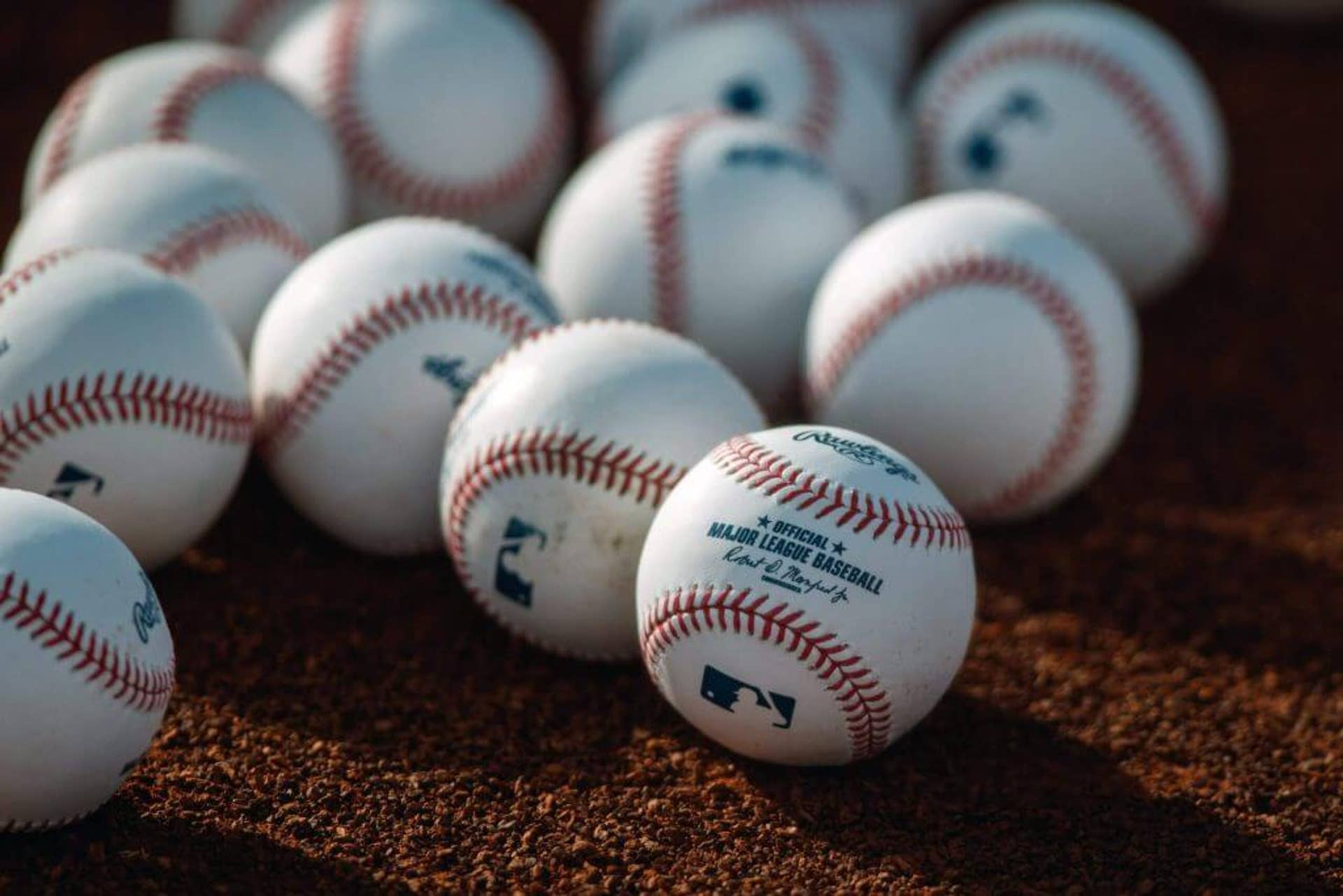 Detailed view of official MLB baseballs on the field during spring training workouts.