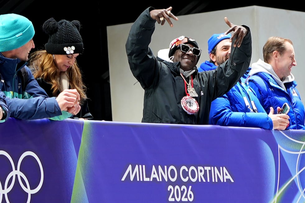American rapper Flavor Flav, center, attends the skeleton mixed team competition at the 2026...