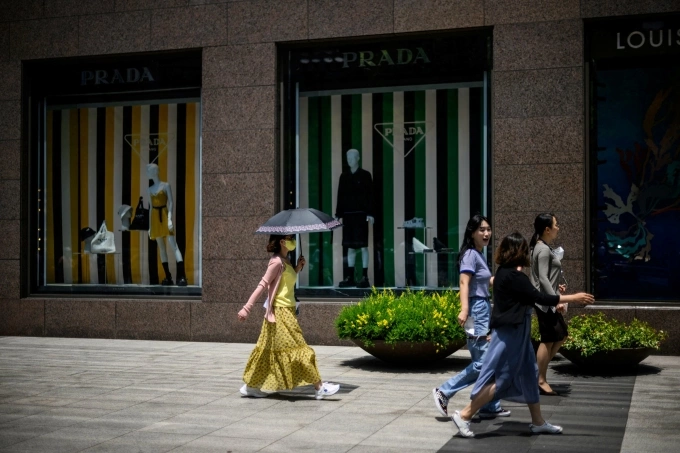 Pedestrians walk past luxury fashion shops in the Gangnam district of Seoul on June 3, 2022. Photo by AFP