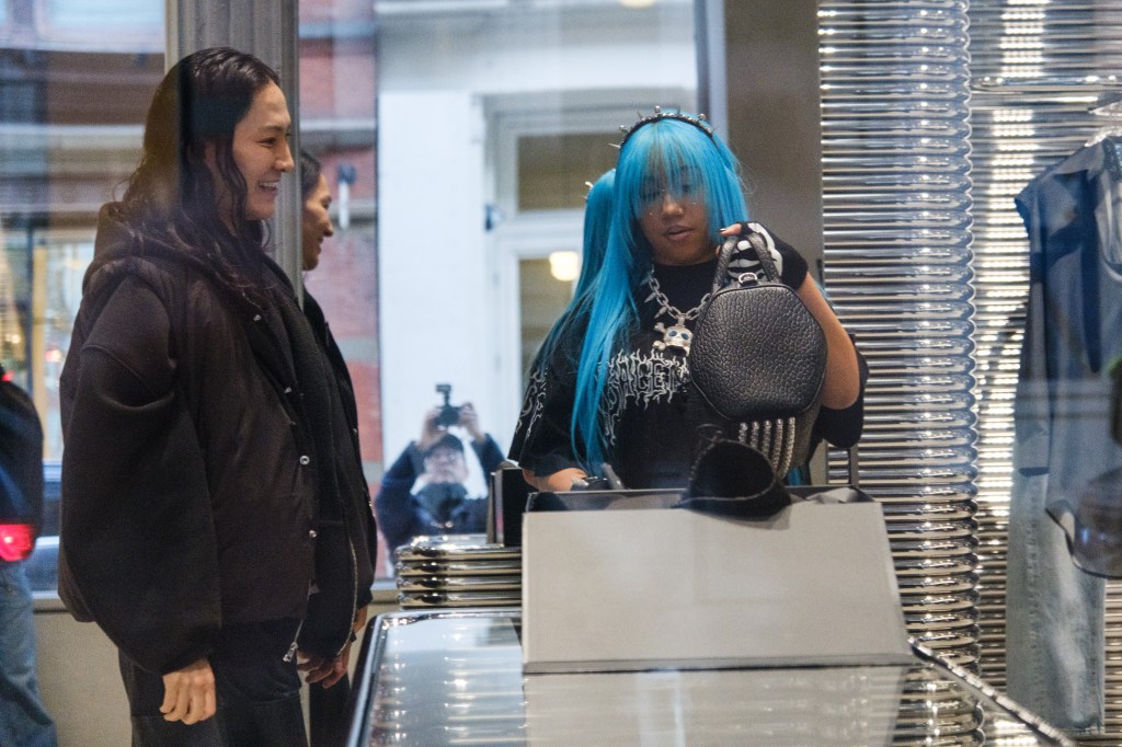 Alexander Wang hands North West a studded leather black bag. 