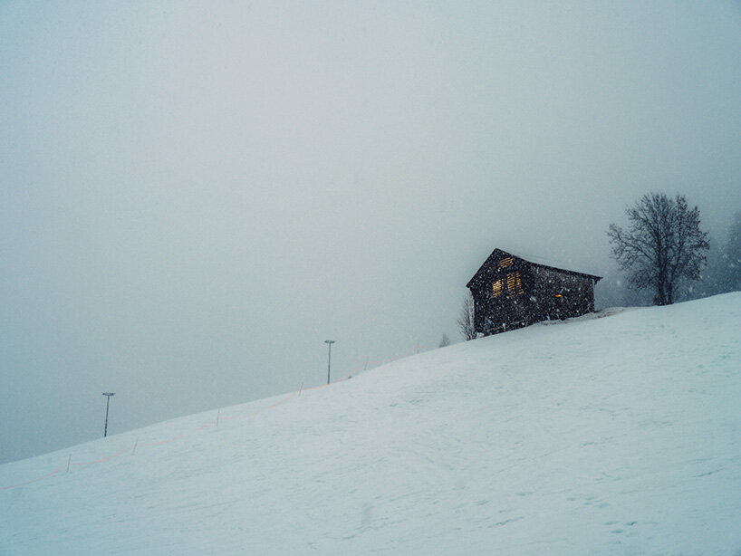alexandre de betak inserts reflective light installation into traditional swiss barn