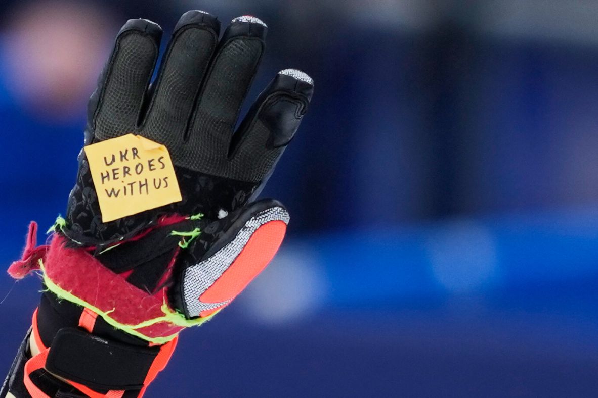 Ukrainian skier Dmytro Shepiuk holds a sticker reading 