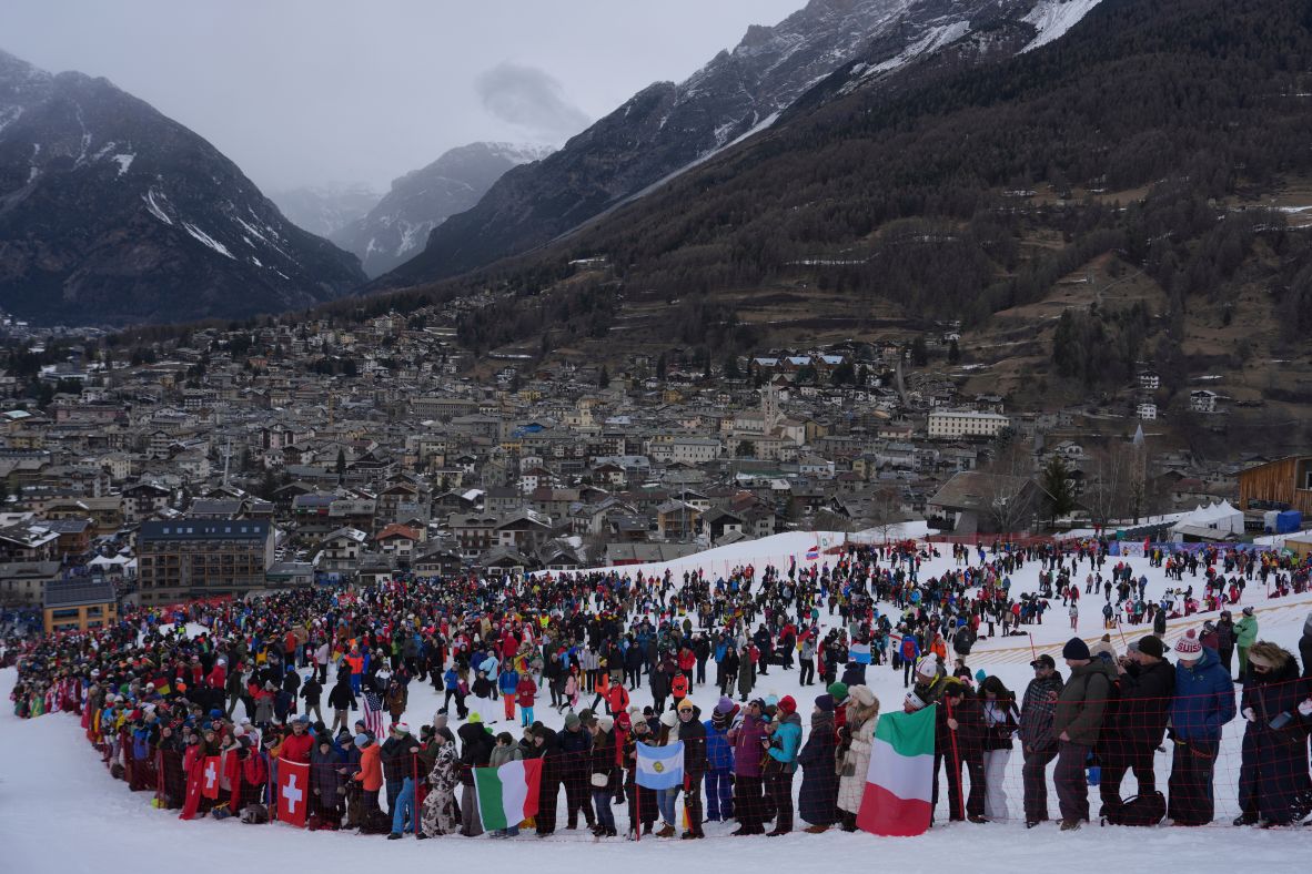Spectators hold flags as they watch the men's giant slalom race on February 14. The cloudy skies brought snow and freezing temperatures to the event.